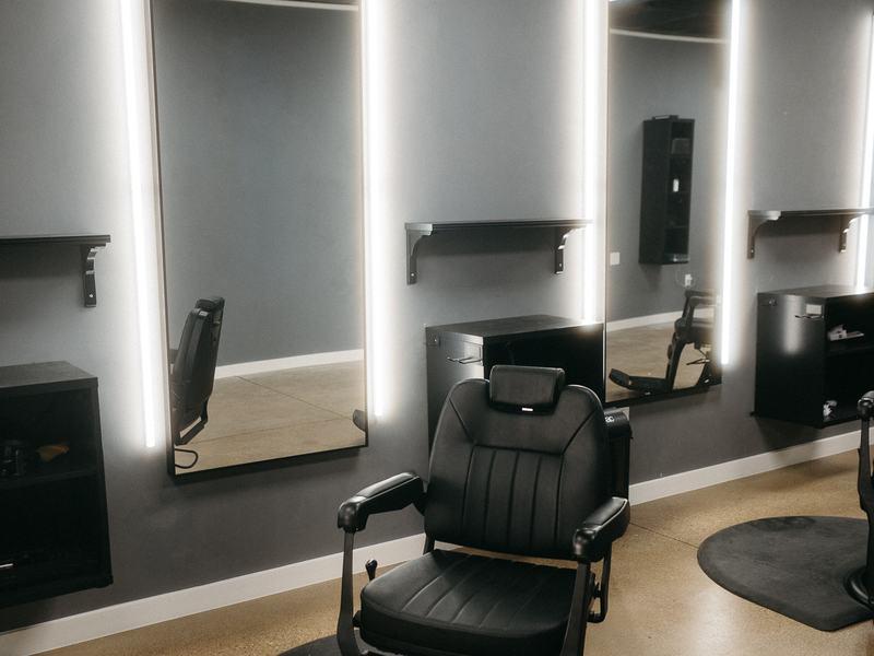 Lit mirrors and barber chair inside Stone Barber, Southlake TX